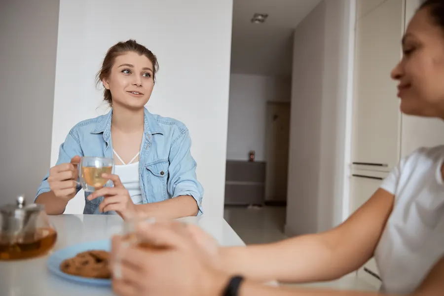 Two women talking over a meal at a kitchen table